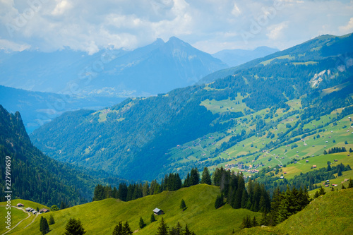 Summer landscape of green hills an mountain village in Switzerland