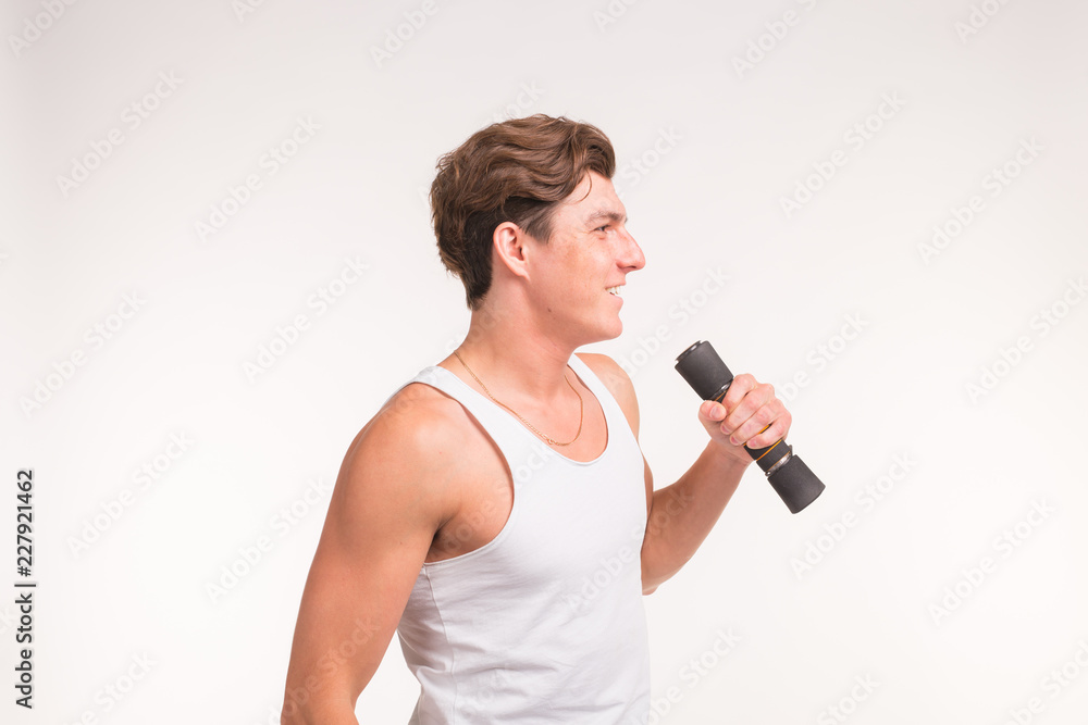 Expression, fitness and people concept - Handsome guy with sports body and dumbbells over white background Expression, fitness and people concept - Handsome guy with sports body and dumbbells over white background