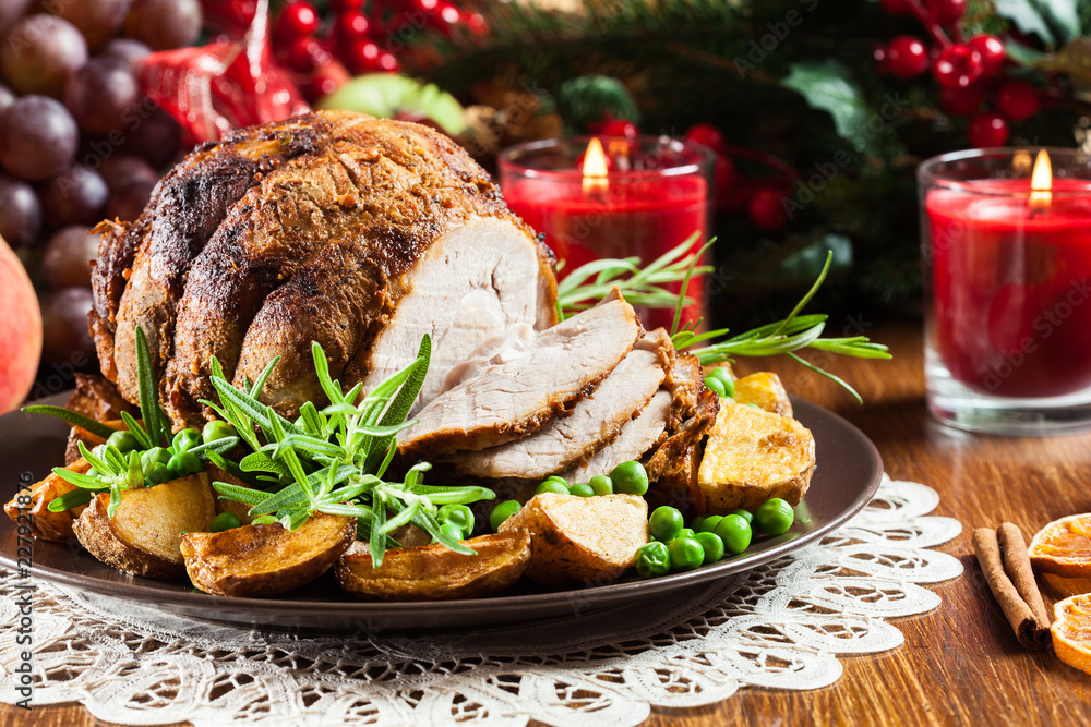Roasted pork ham served with baked potatoes Roasted pork ham served with baked potatoes