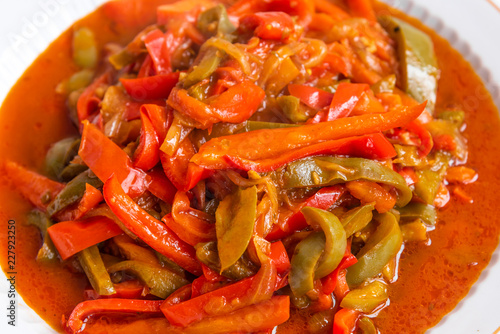 Italian food - peperonata from peppers, onions and tomatoes, on a large plate close-up photo