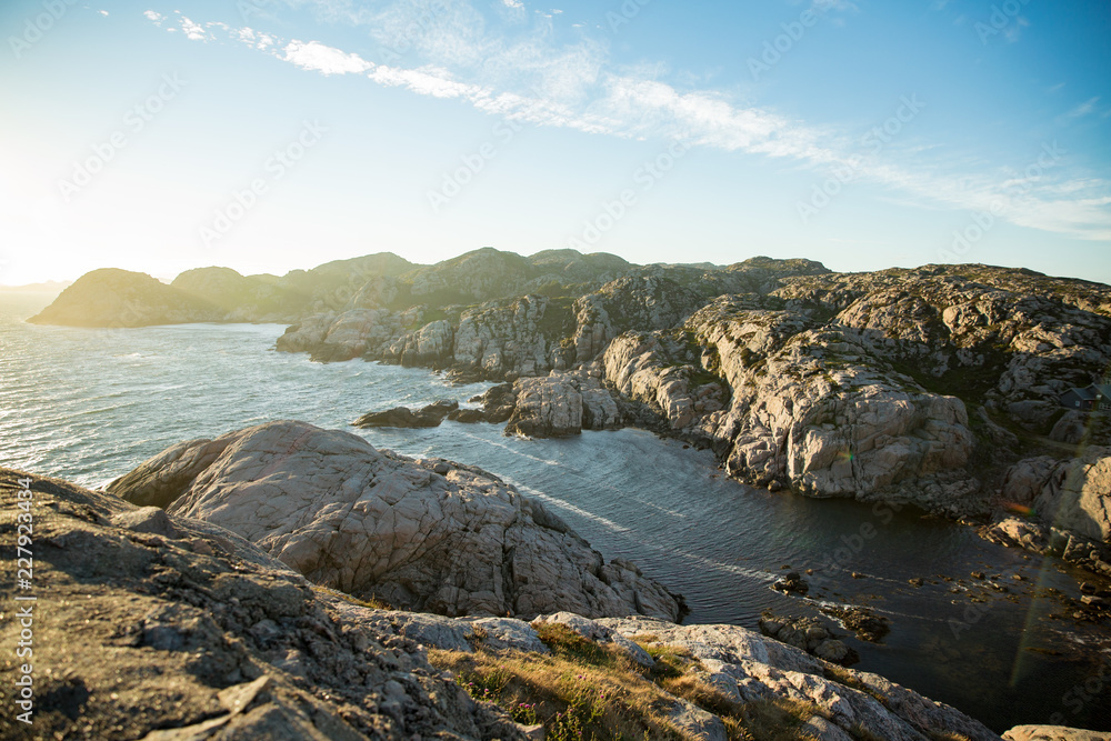 Serene scandinavian summer landscape on south coast of Norway. Rocky Mountains, fjord from top. Sunset sky. Lindesnes