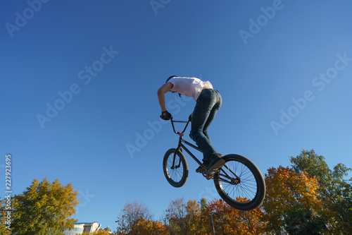 Image of the biker doing stunt in the blue sky