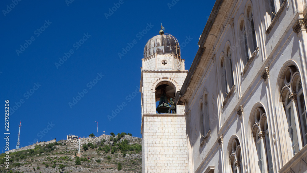 The clock tower of Dubrovnik with the mountain Srd in the background