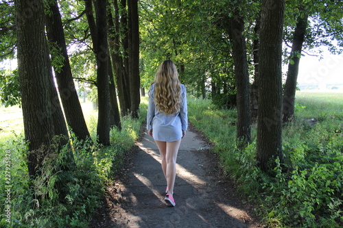 young woman walking in the forest © Alymov