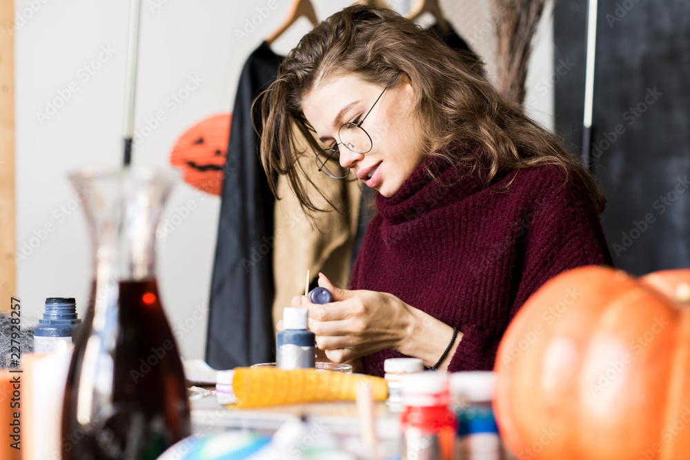 Positive woman reading label on paint jar Positive woman reading label on paint jar