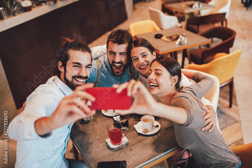 Group of Happy friends having making selfie in cafe photo