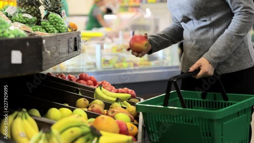 Woman buys fruit in a supermarket