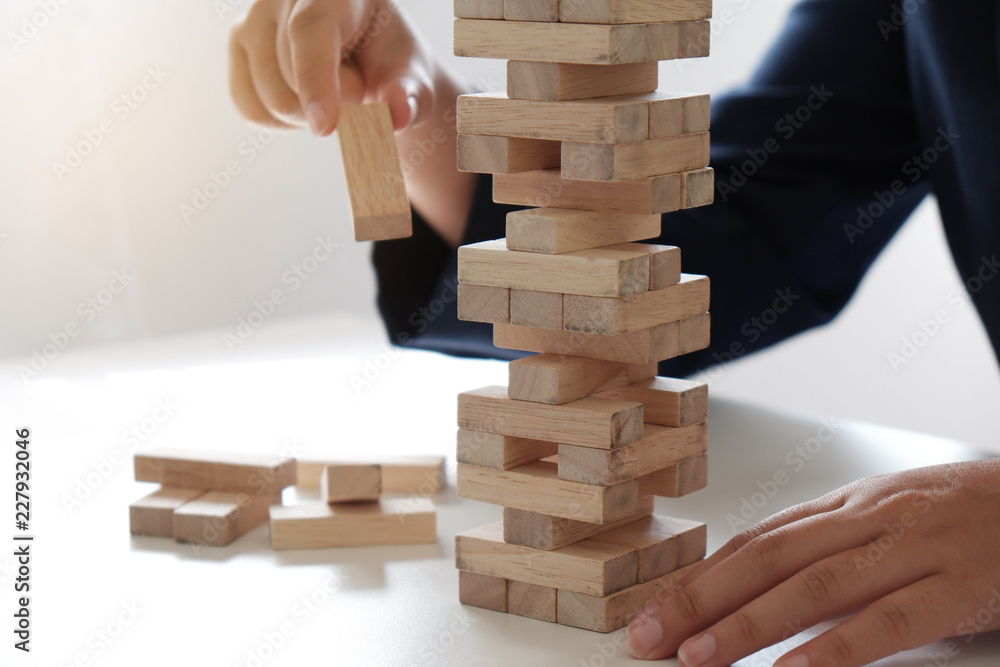 Closeup of women playing wood blocks stack game, concept of business growth, glambling, risk. Closeup of women playing wood blocks stack game, concept of business growth, glambling, risk.