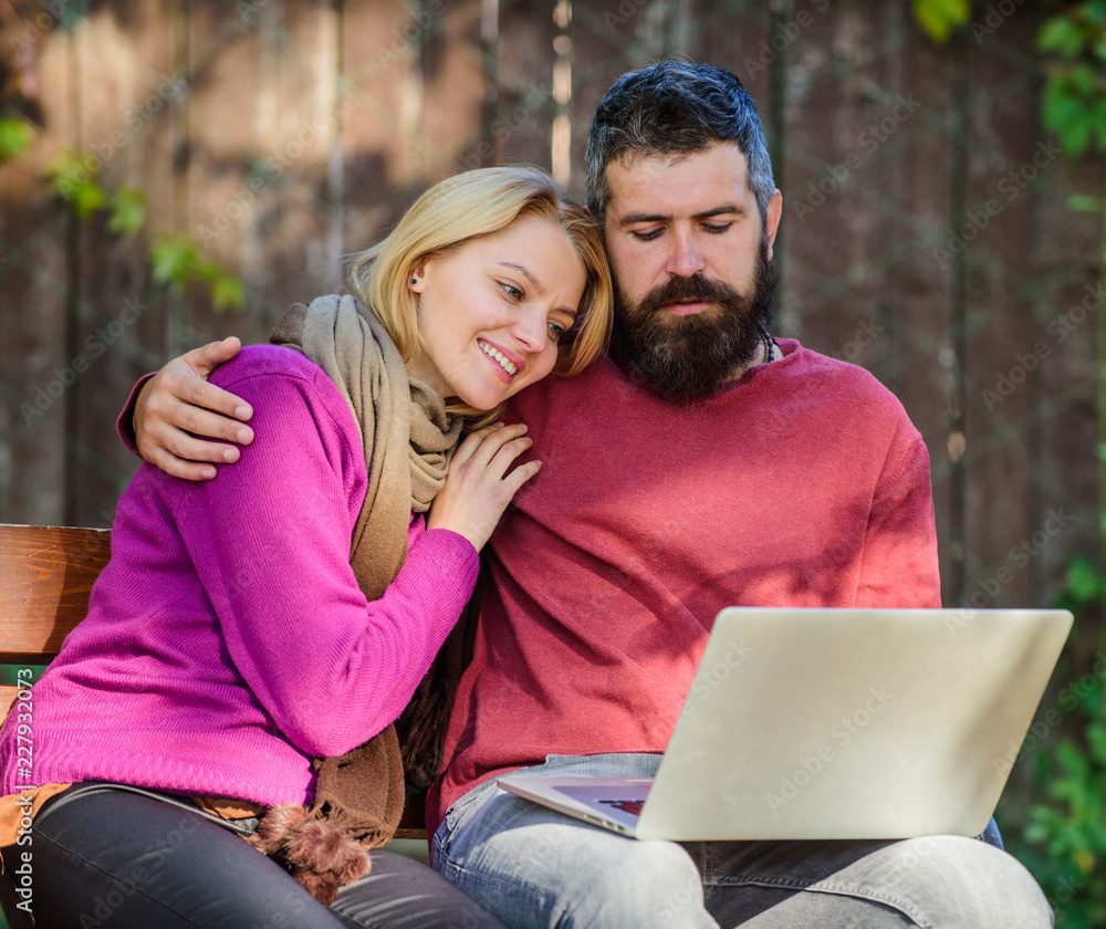 Couple in love notebook consume content. Couple with laptop sit bench in park nature background. Surfing internet together. Family surfing internet for interesting content. Internet surfing concept Couple in love notebook consume content. Couple with laptop sit bench in park nature background. Surfing internet together. Family surfing internet for interesting content. Internet surfing concept