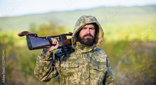 Bearded hunter rifle nature background. Hunting big game typically requires tag each animal harvested. Experience and practice lends success hunting. Hunting season. Guy hunting nature environment