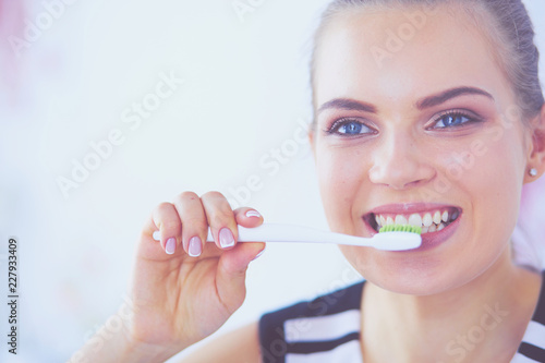 Young pretty girl maintaining oral hygiene with toothbrush.