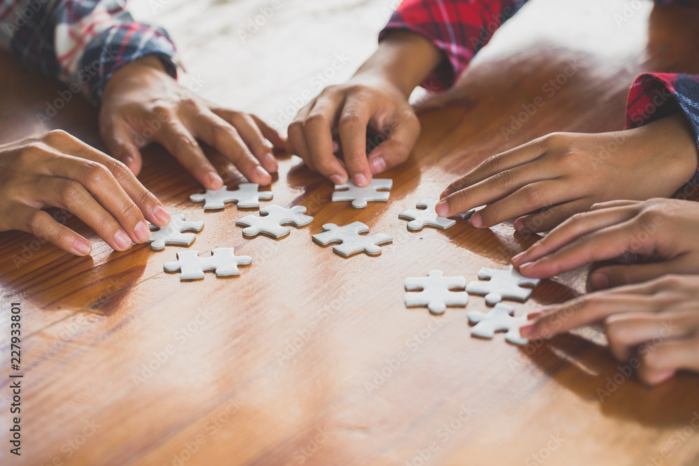 Hands of diverse people assembling jigsaw puzzle, Youth team put pieces together searching for right match, help support in teamwork to find common solution concept, top close up view Hands of diverse people assembling jigsaw puzzle, Youth team put pieces together searching for right match, help support in teamwork to find common solution concept, top close up view