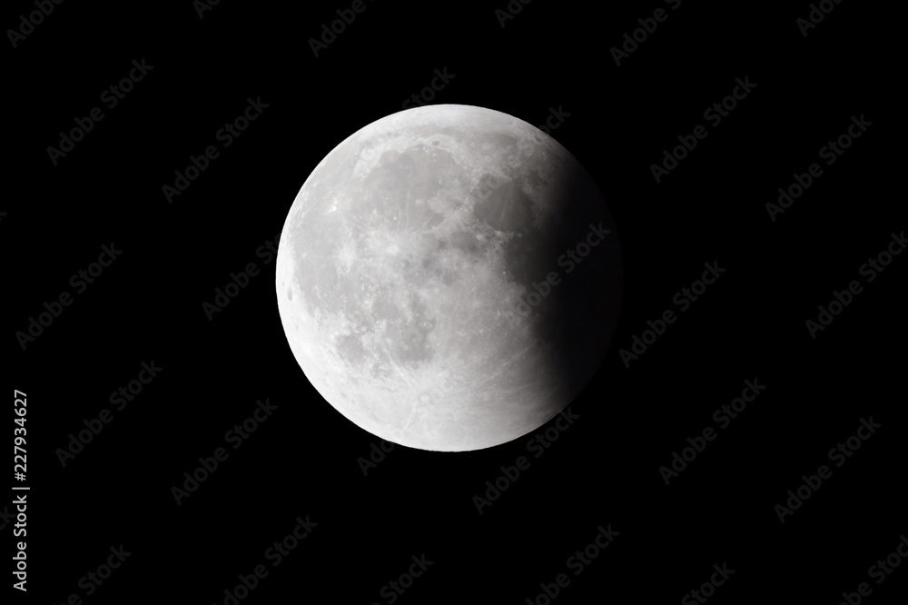 Obraz premium Super Bloody Moon, full eclipse last phase against black sky background, quarter of the Moon surface covered by Earth's shadow