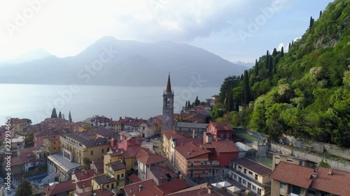 Aerial view como lake. Flying over old european town on the shore. View on the city below building with red tilled roof and tower.Varenna, Italy photo