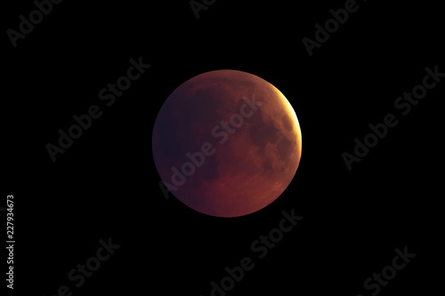 Super Bloody Moon, first phase of full eclipse against black sky background