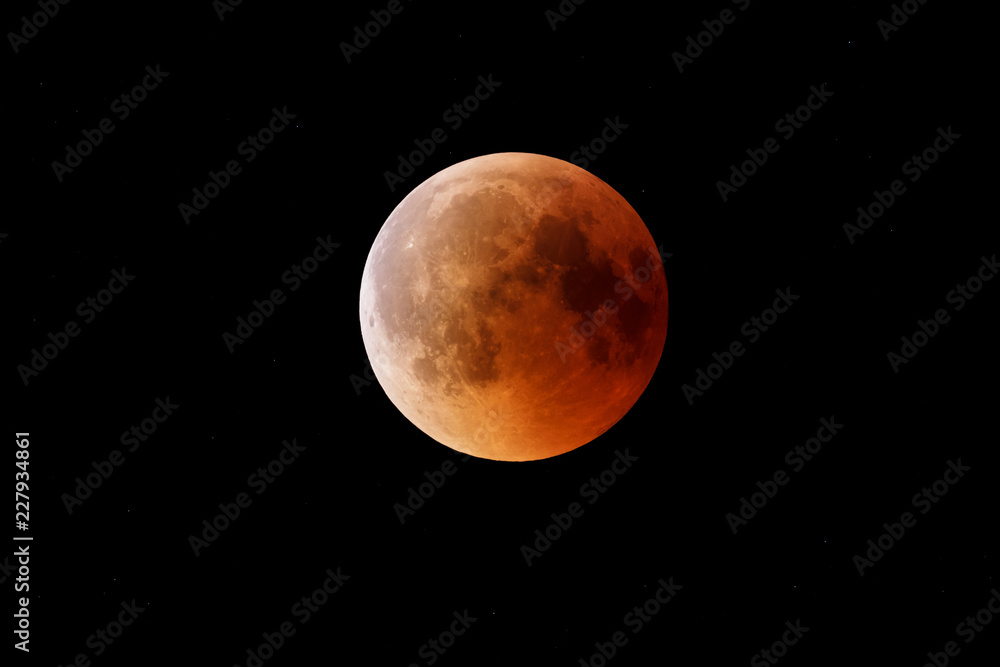 Super Bloody Moon, beginning of full eclipse end phase against starry sky background Super Bloody Moon, beginning of full eclipse end phase against starry sky background