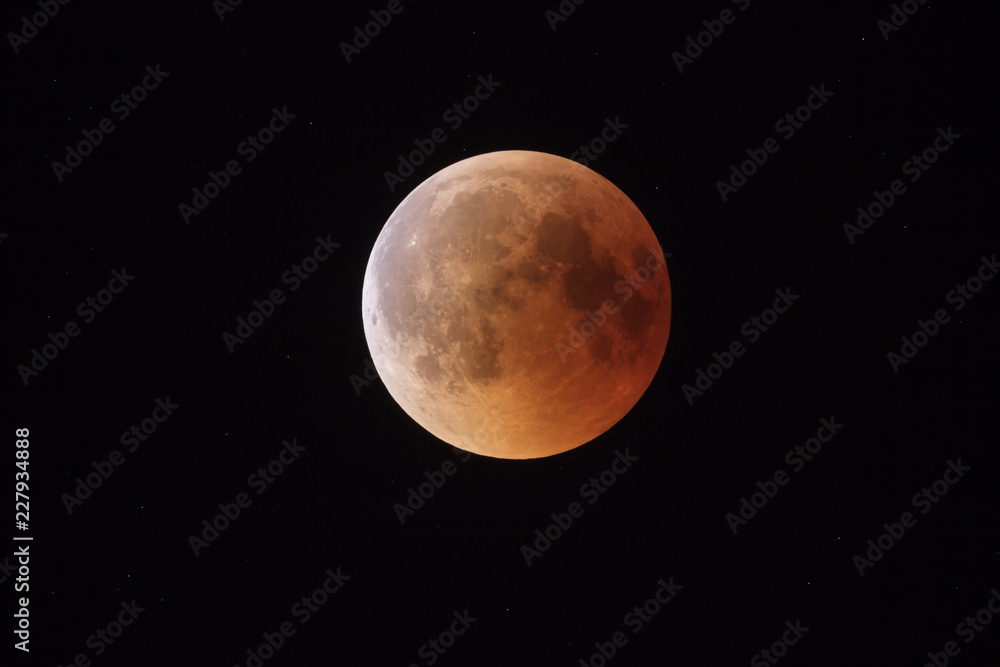 Super Bloody Moon, beginning of full eclipse end phase against starry sky background Super Bloody Moon, beginning of full eclipse end phase against starry sky background