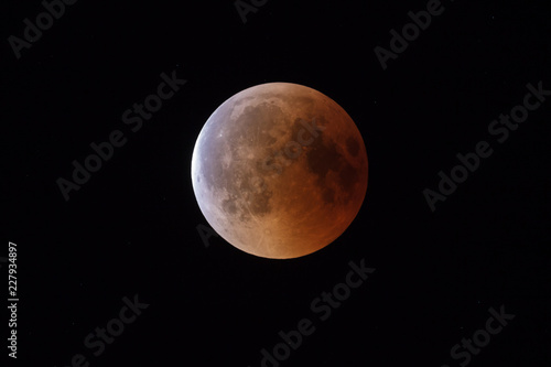 Super Bloody Moon, beginning of full eclipse end phase against starry sky background