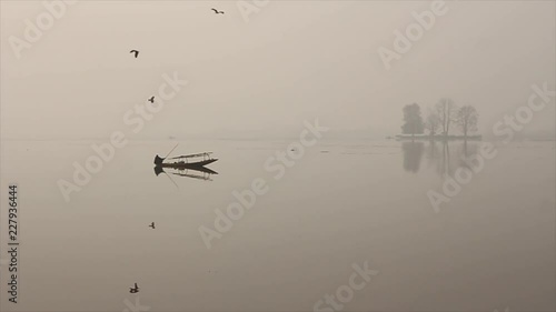 Lone boatman with his boat on a lake