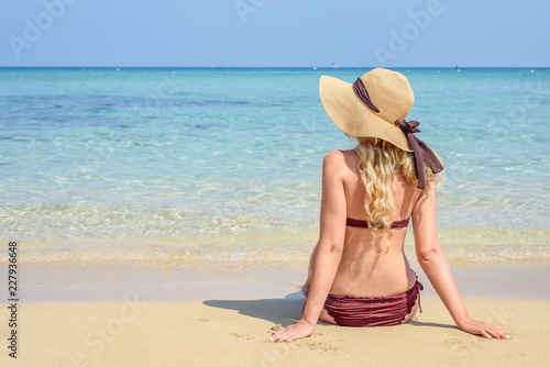 Woman at the beach in Cyprus. Hat and swimsuite. Beautiful Summer seaside vie...