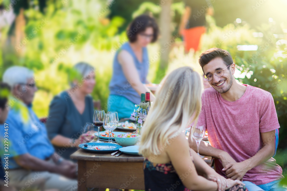 Summertime, cheerful family gathered for picnic in the garden Summertime, cheerful family gathered for picnic in the garden