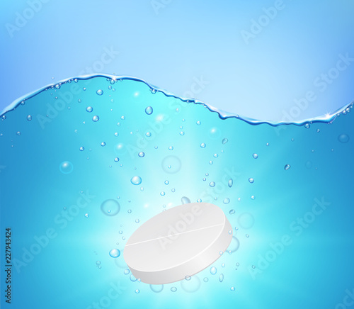 Effervescent soluble tablet falling down under the water with bubbles