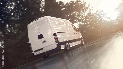 Weißer Transporter fährt schnell auf einer nassen Landstraße der Sonne entgegen