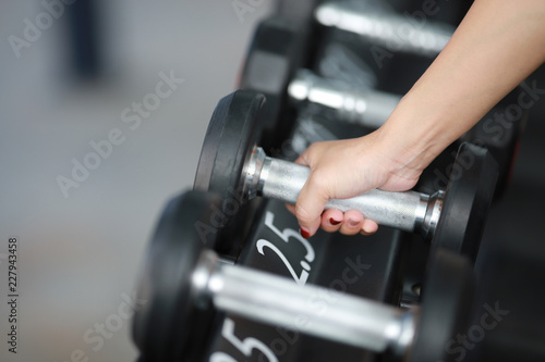 Woman hand holding a dumbbell in the gym.