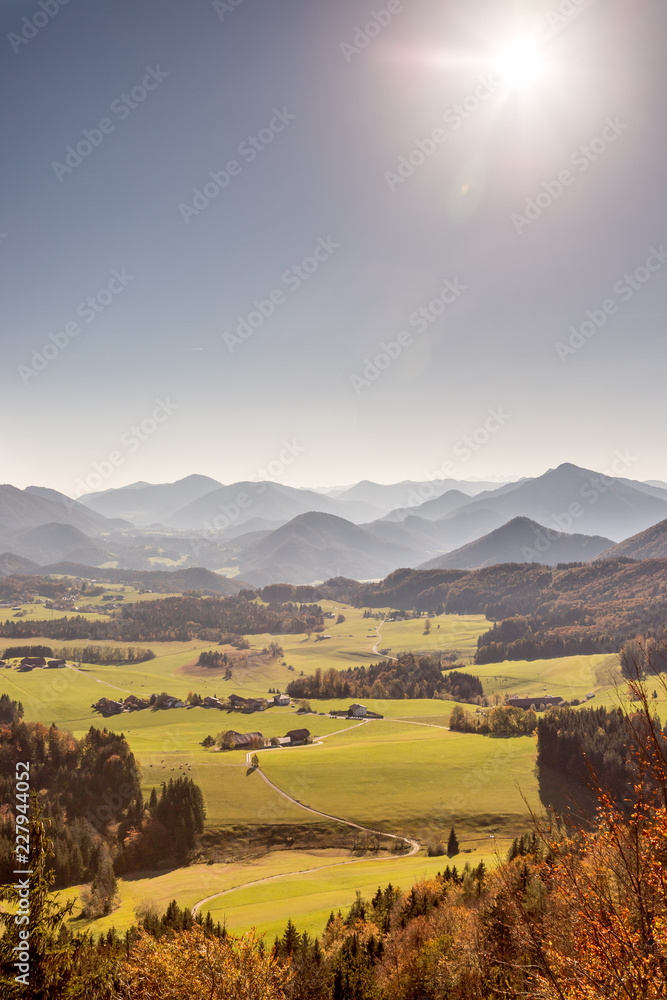 Fototapeta Aussicht auf grünes Flachland und Bergland im Hebst, Hochformat