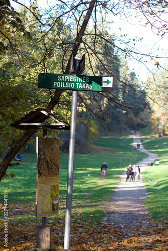 Vilnius, Lithuania,13 oct,2018: Direction sign in Antakalnis area to Sapiegos park and forest in Vilnius, Lithuania with people walking in the background. People relaxing in Sapiegos park,Vilnius