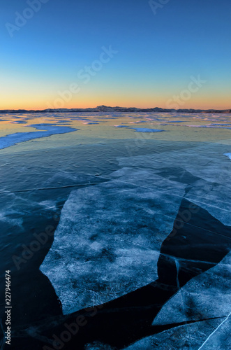 View of beautiful drawings on ice from cracks and bubbles of deep gas on surface of Baikal lake in winter, Russia