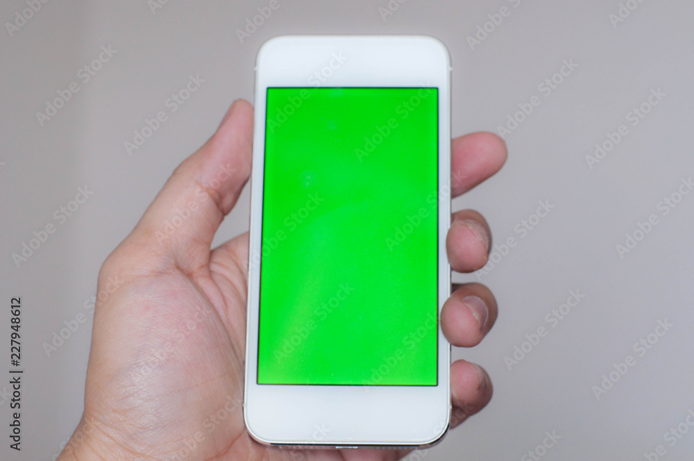 Young man holding a smart phone with green screen Young man holding a smart phone with green screen