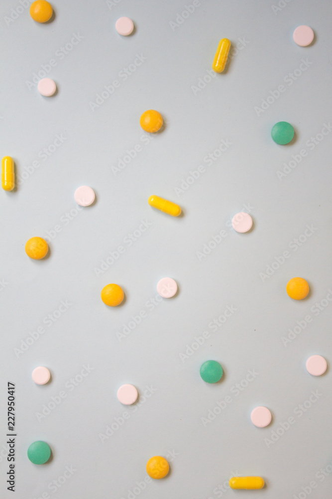 Pattern of white, green and orange pills and tablets on a blue background. Assorted pharmaceutical medicine pills, Flat lay