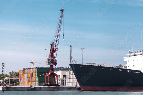Cargo containers in the port. Marine crane lifts the cargo container. Import export transportation, logistics business, customs.