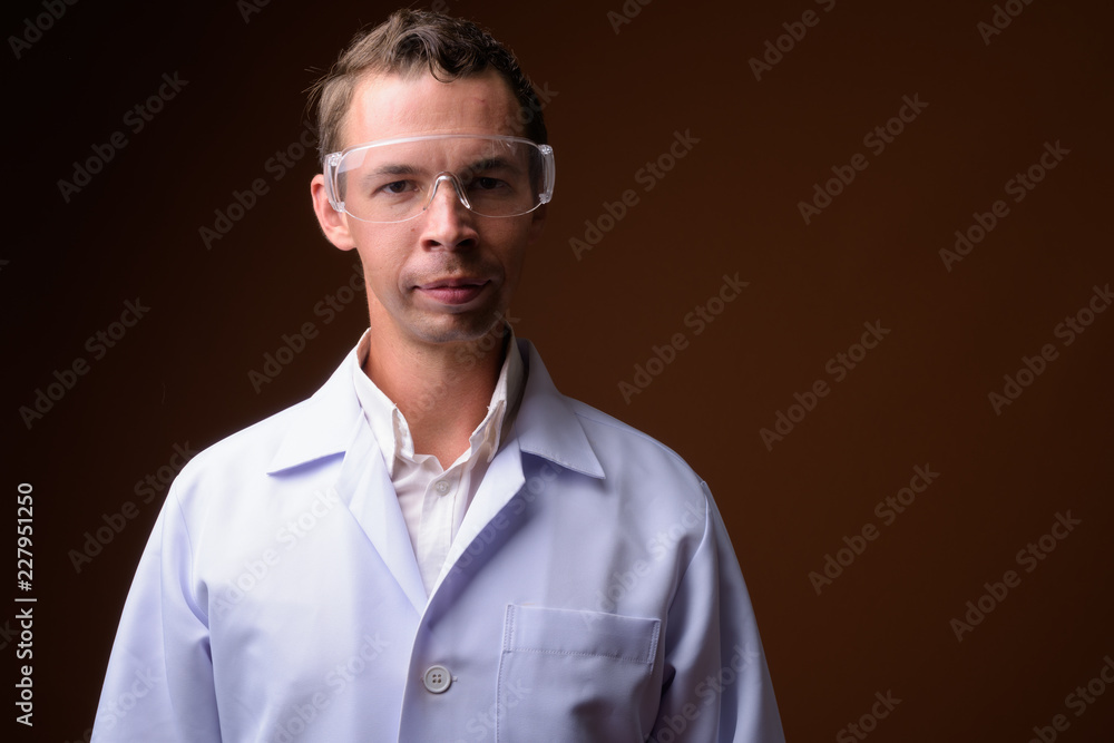 Studio shot of man doctor against brown background Studio shot of man doctor against brown background