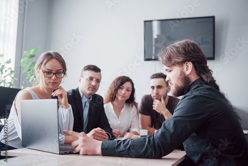 Colleagues communicate with work questions in modern office space