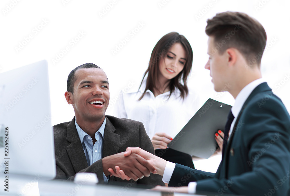 handshake of business partners sitting at a table Desk handshake of business partners sitting at a table Desk