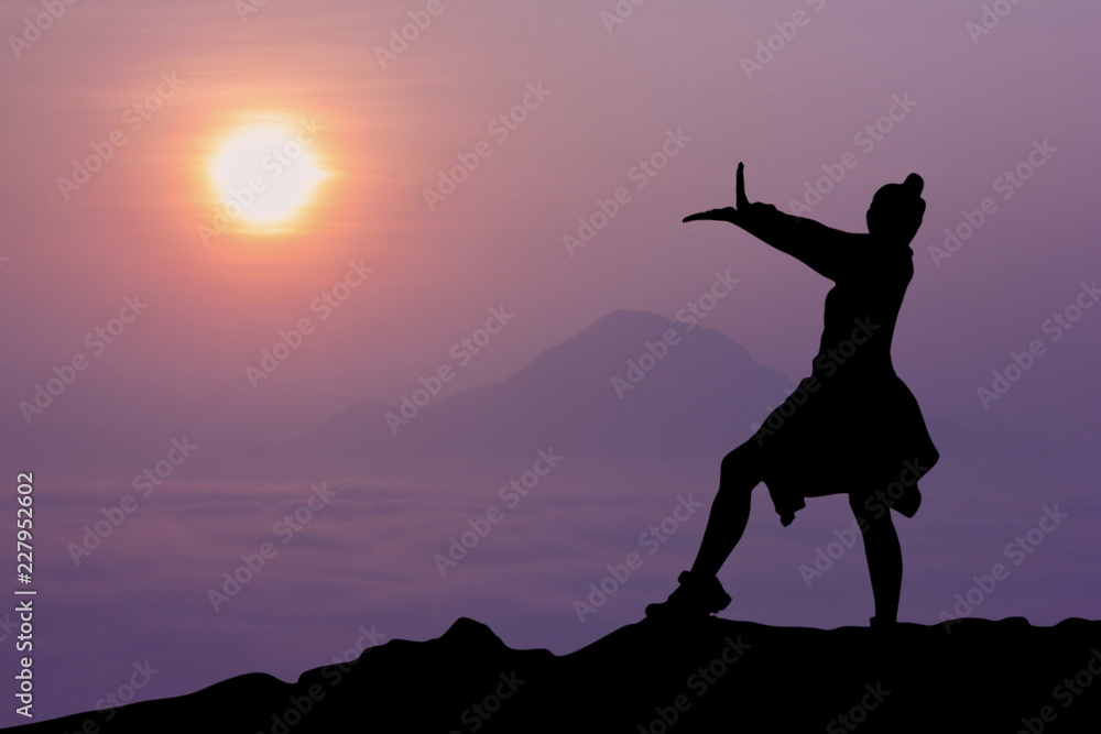 silhouette of a woman standing on the mountains with sunrise in the morning.