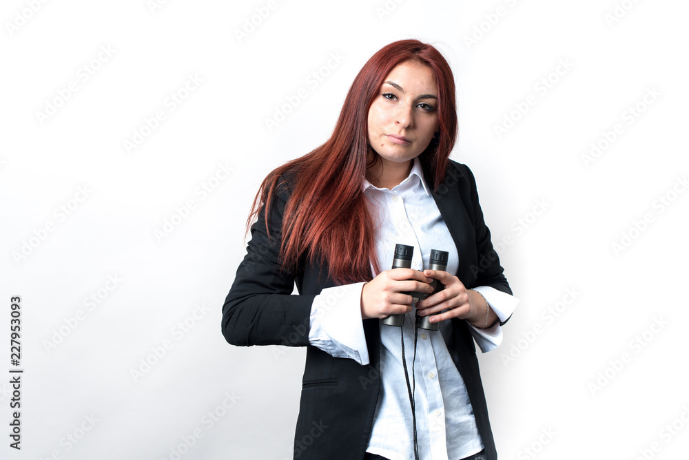 a woman with binoculars in the hands stands on a light background, she is dressed in a black jacket and white shirt, she is looking for something a woman with binoculars in the hands stands on a light background, she is dressed in a black jacket and white shirt, she is looking for something