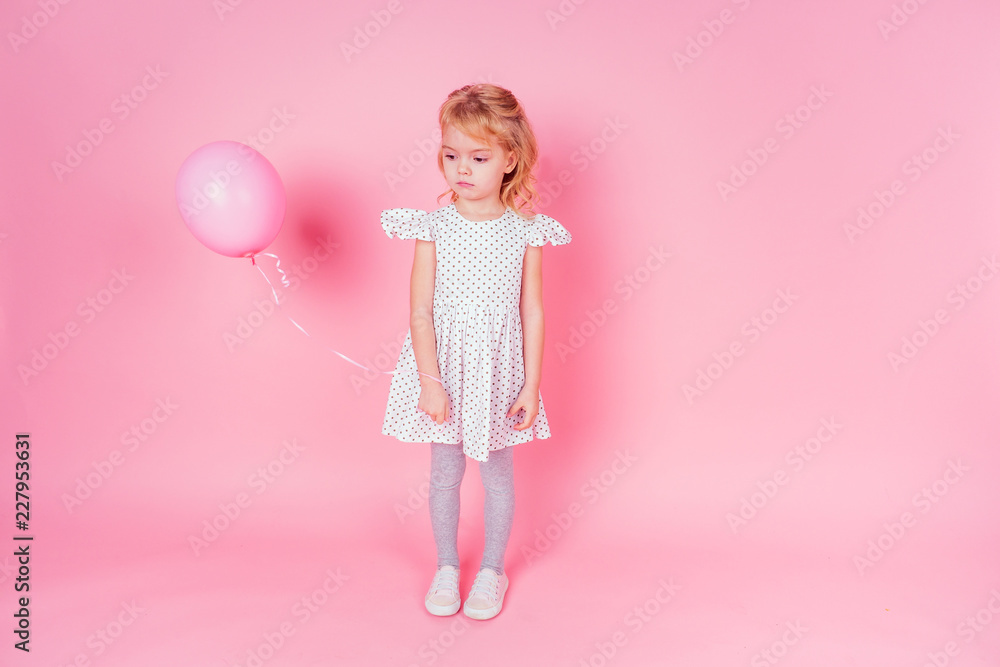 sad little blonde girl in white dress in peas 4-5 year old holding balloon in the studio on a pink background,birthday celebration ,sadness and disappointment sorrow sad little blonde girl in white dress in peas 4-5 year old holding balloon in the studio on a pink background,birthday celebration ,sadness and disappointment sorrow