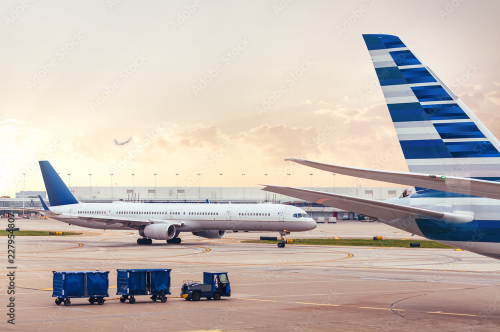 Fototapeta premium Two airplanes on tarmac with cargo at airport