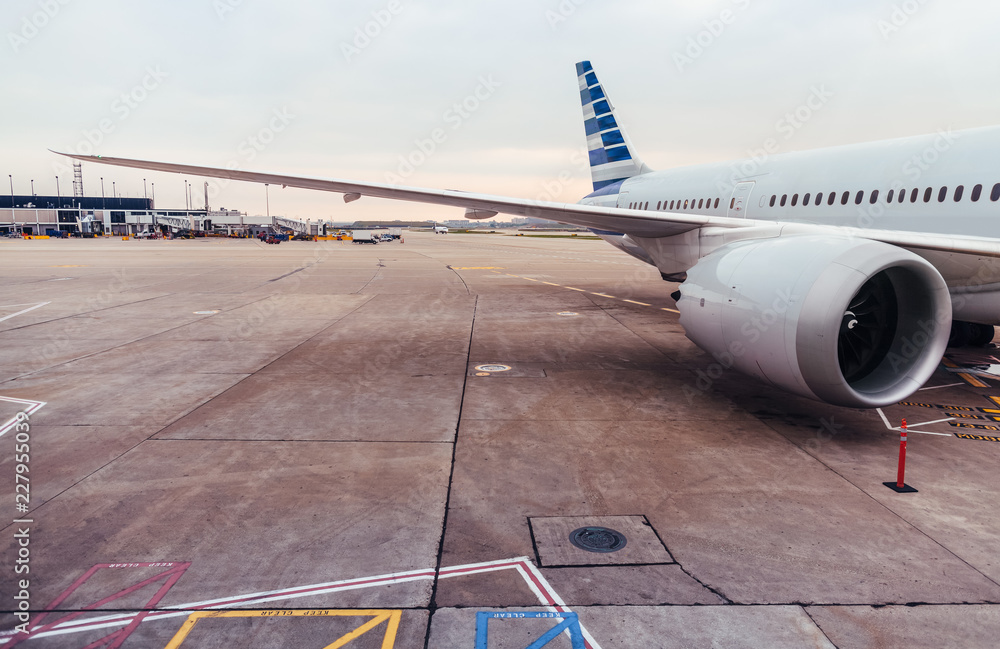 Obraz premium View of airplane wing and engine on tarmac at airport