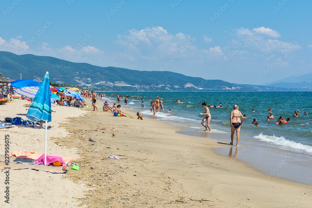 Fototapeta premium Asprovalta, Greece - August 20, 2018: Asprovalta and New Vrasna resort, Asprovalta beach. Sea view to Asprovalta at the foot of the green hills.