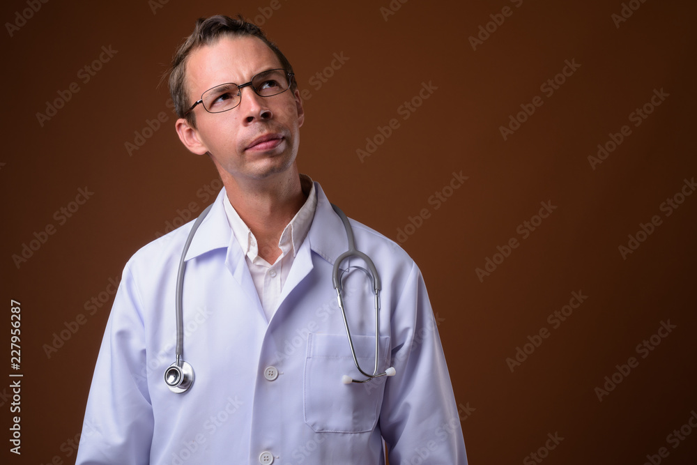 Studio shot of man doctor against brown background Studio shot of man doctor against brown background