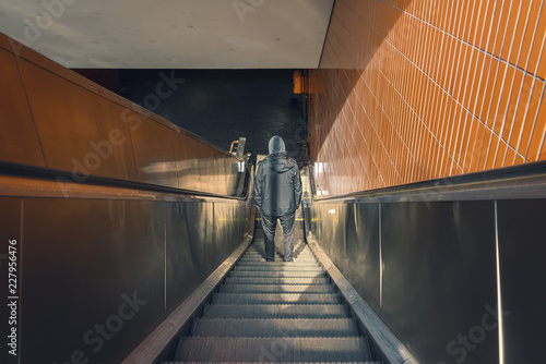 Berlin Underground, back view of a young man on an escalator photo