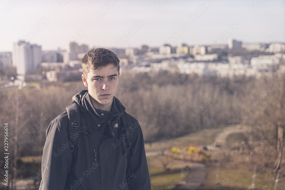 portrait of a young man with a skyline of skyscraper in background