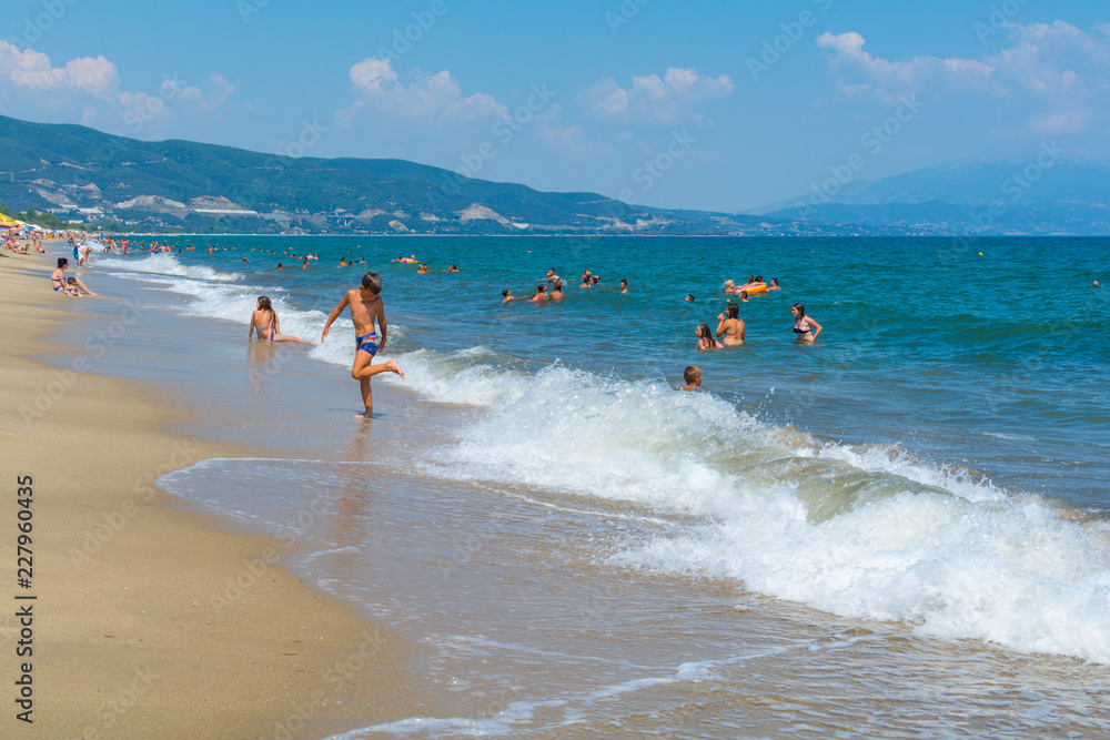 Fototapeta premium Asprovalta, Greece - August 20, 2018: Asprovalta and New Vrasna resort, Asprovalta beach. Sea view to Asprovalta at the foot of the green hills.