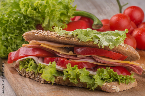 Foto Sandwich with salami, cheese and salad in integral roll