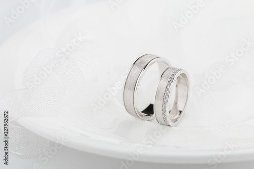 Pair of white gold wedding rings with matte surface and diamonds