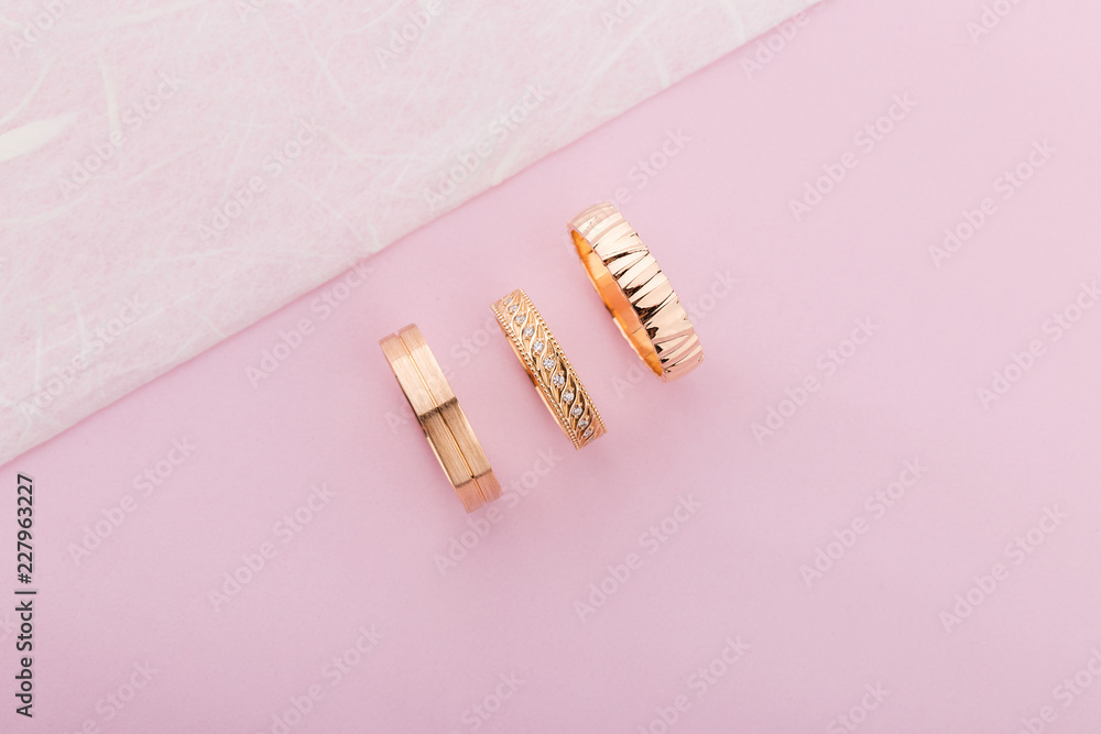 Stylish pink gold rings with different design on pink background Stylish pink gold rings with different design on pink background